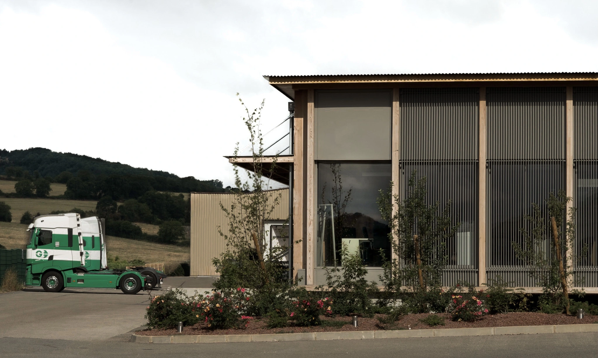Extension du siège social des Transports Galtier avec façade en bois et camion de l'entreprise à Roquefort-sur-Soulzon