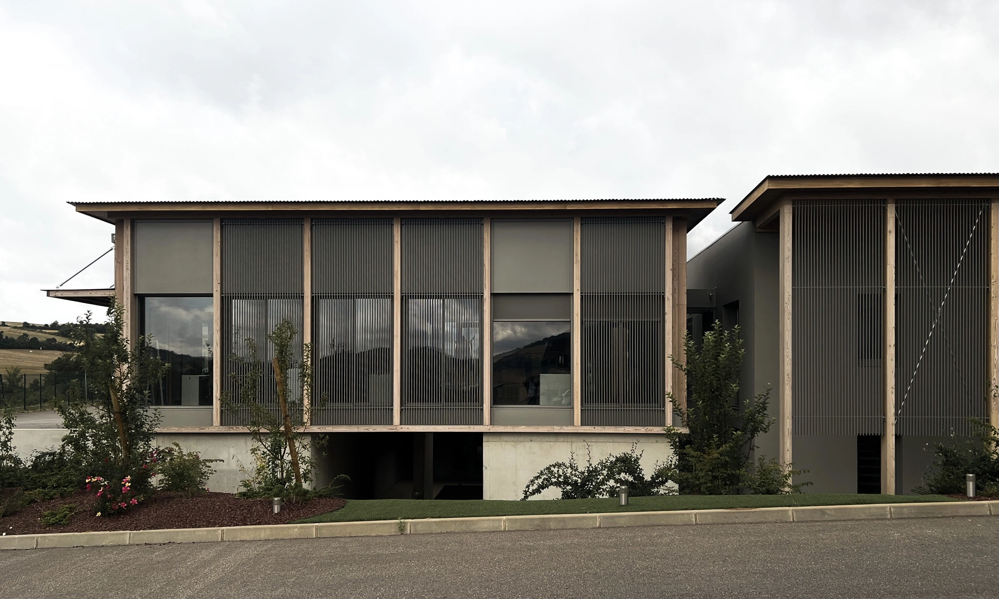 Vue générale de l'extension du siège des Transports Galtier avec façades en bois et brise-soleil métalliques
