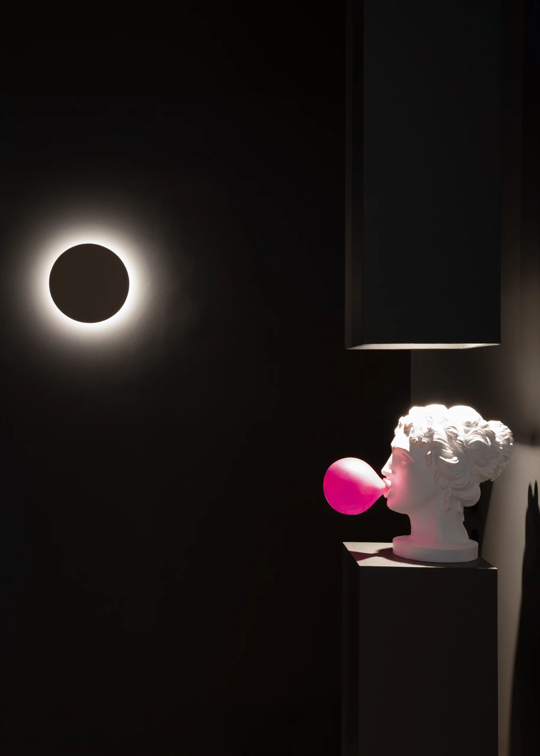 Sculpture blanche soufflant une bulle rose dans un espace sombre du cabinet du DR. Lange à Montpellier