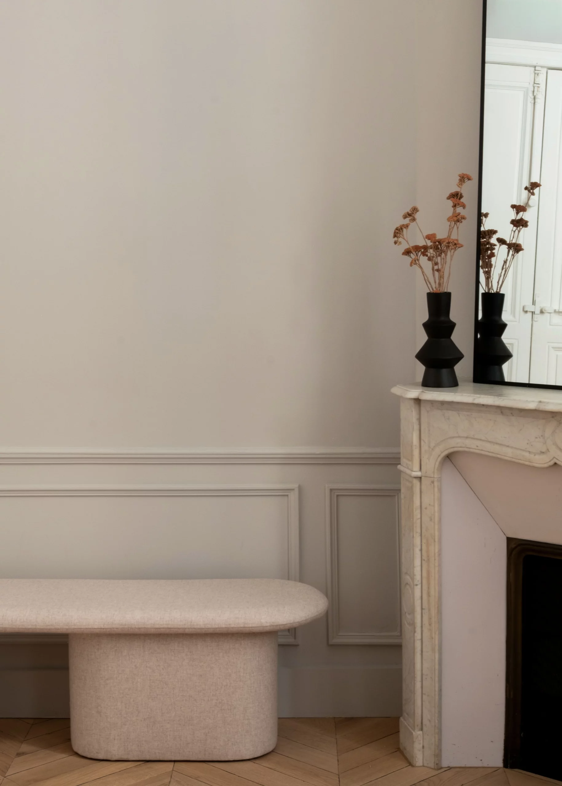 Cheminée en marbre, miroir et banquette dans le cabinet du Dr Lange aménagé dans un appartement haussmannien à Montpellier