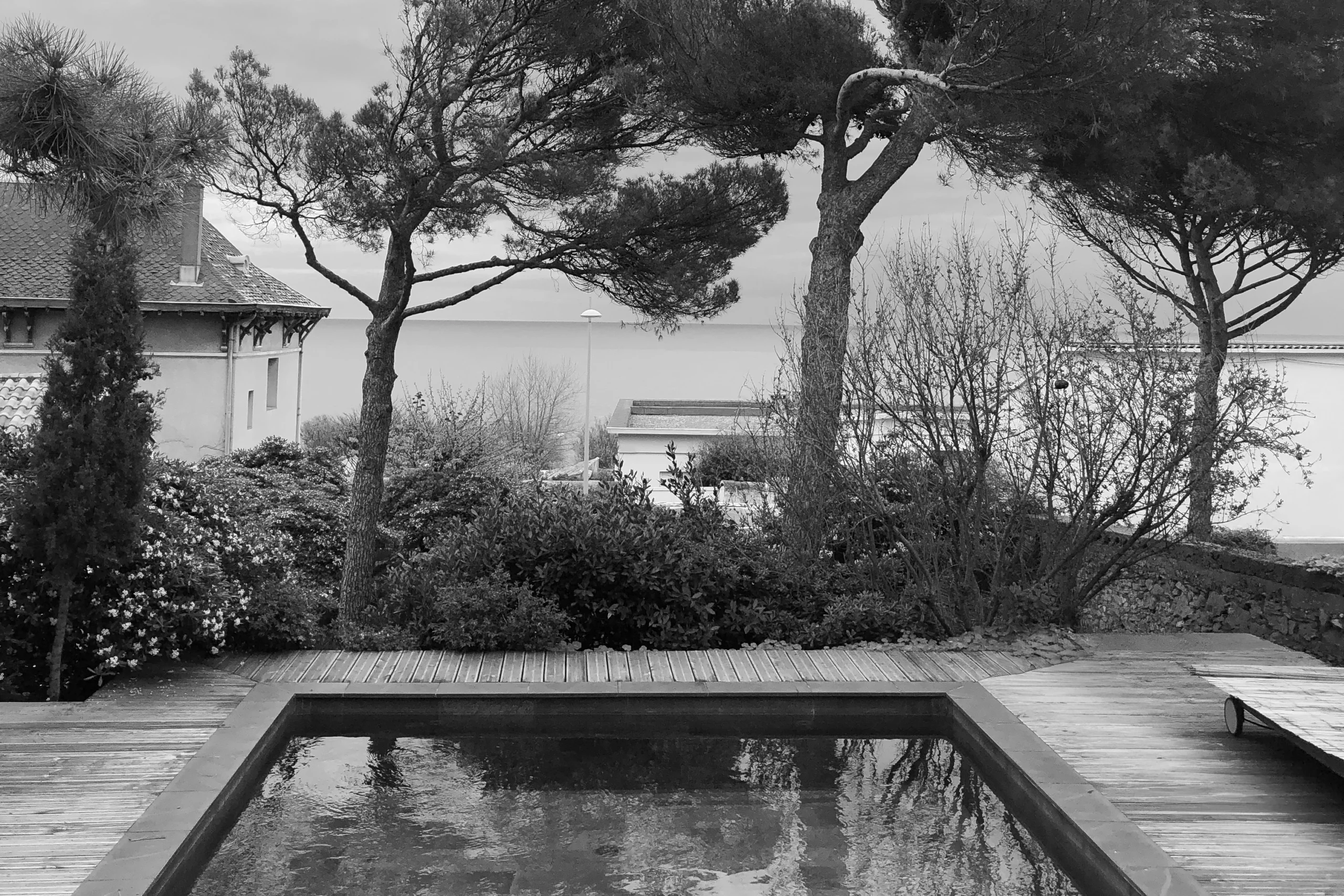 Photographie de l'état existant avant rénovation, montrant une piscine et une terrasse en bois face à la mer Méditerranée sur le mont Saint-Clair à Sète.